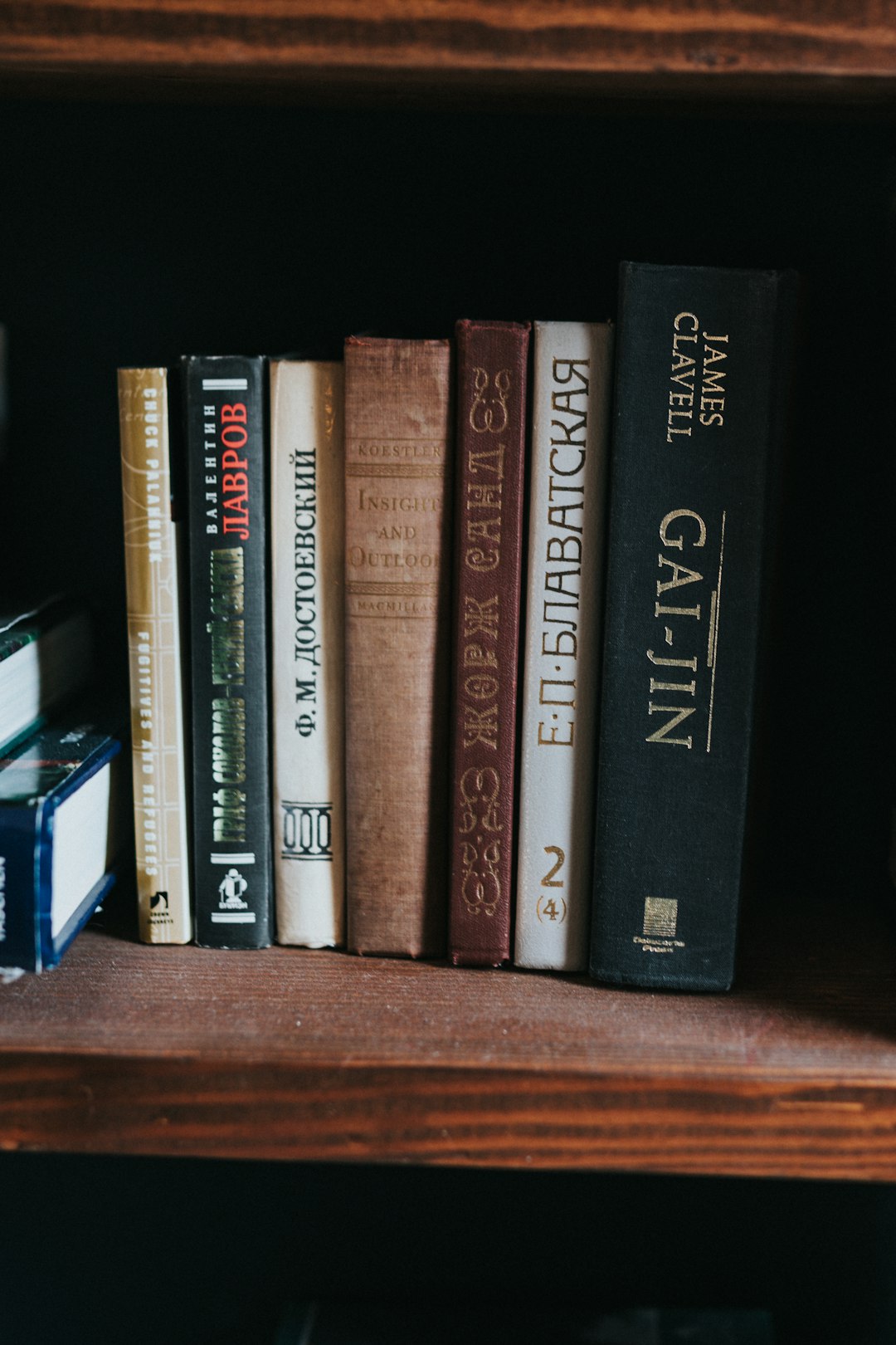 black and brown books on brown wooden shelf