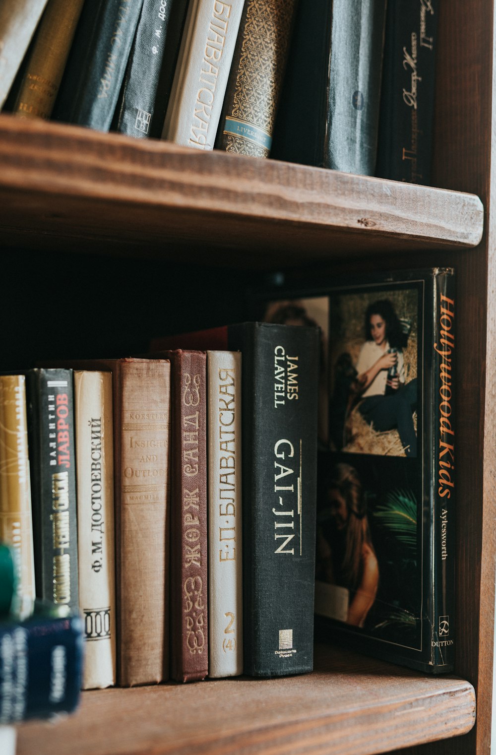 a bookshelf filled with lots of books on top of a wooden shelf