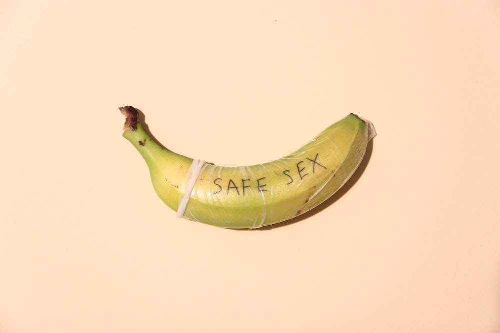 Banana wrapped in condom. On condom "safe sex" is written
