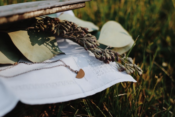 Silver leg chain resting beside a small bouquet of wildflowers for a delicate touch.