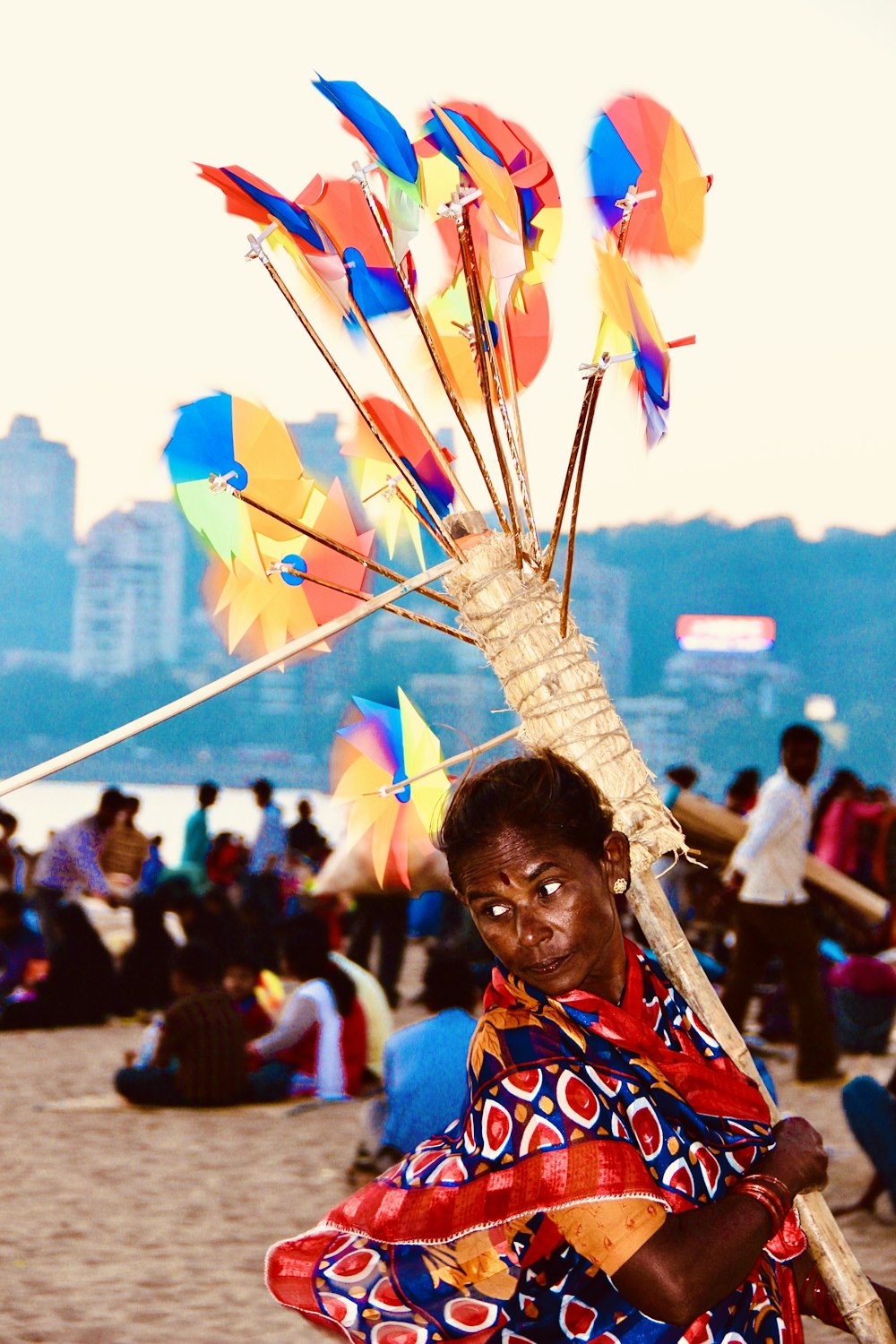 woman in red and yellow sari dress holding yellow and blue umbrella during daytime