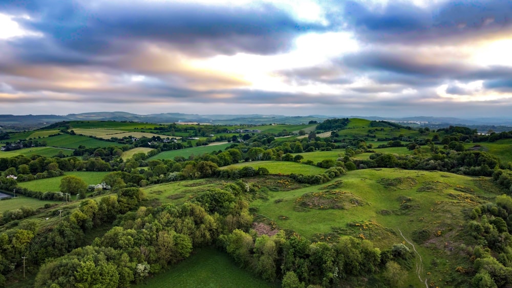 green grass field under cloudy sky during daytime