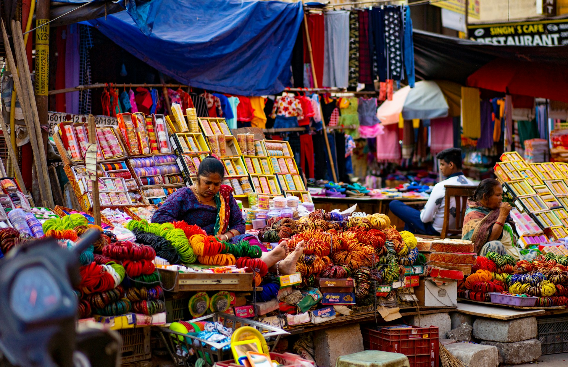 woman in blue and yellow long sleeve shirt sitting on brown wooden chair