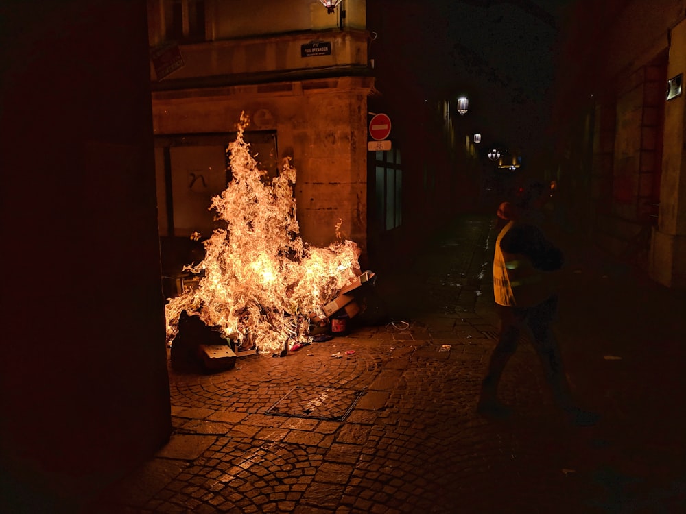 Hombre con camisa amarilla de pie cerca del fuego