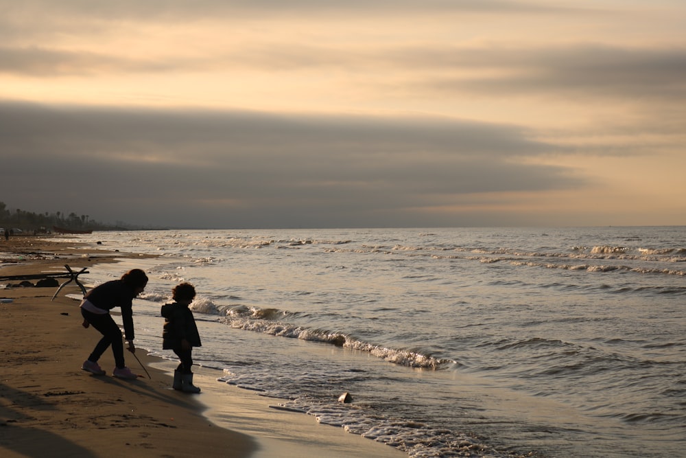 man and woman walking on beach during daytime