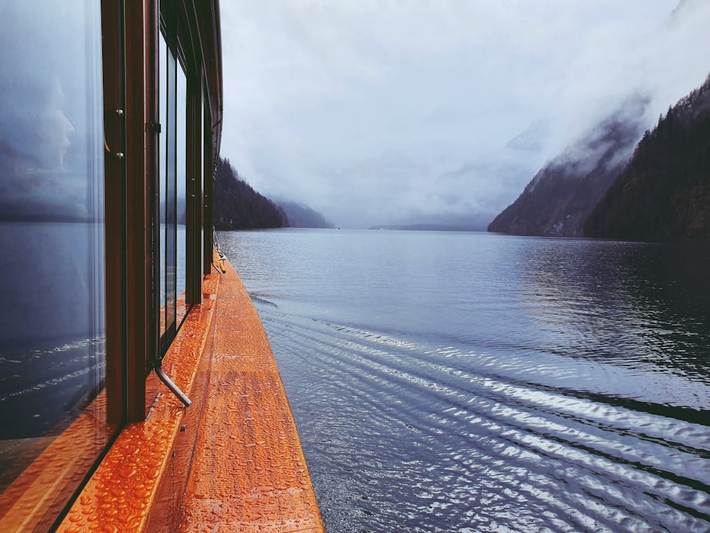 molo di legno marrone sullo specchio d'acqua durante il giorno