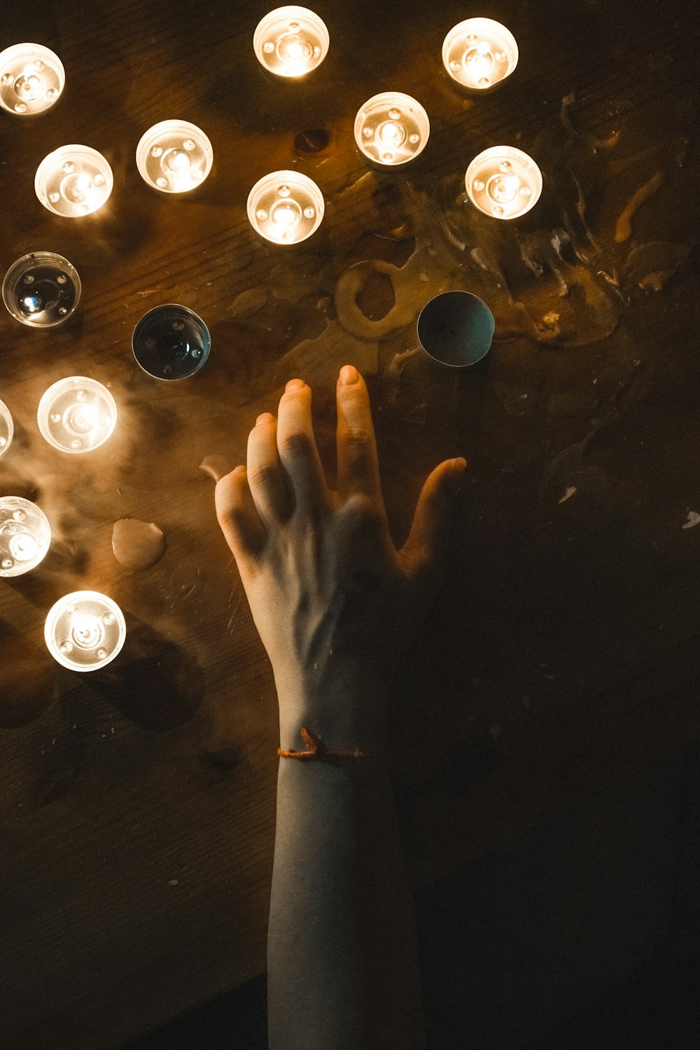 persons hand on black surface with water droplets