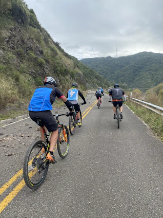 Cyclists riding gravel bikes through scenic countryside roads in Pantón under a clear sky.