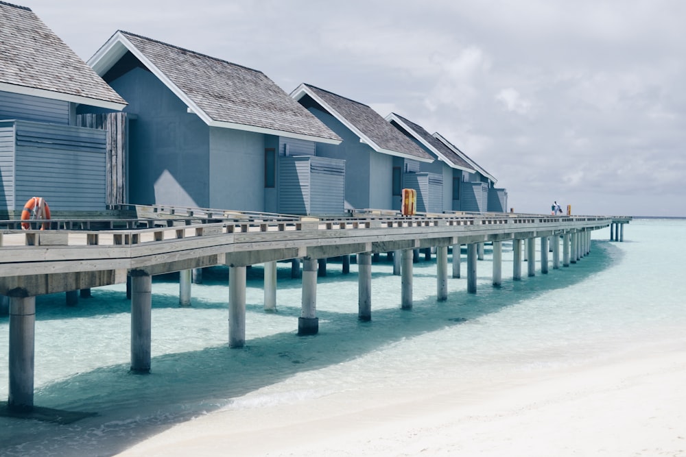 a row of houses sitting on top of a wooden pier