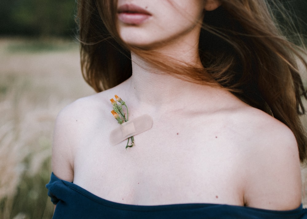 woman in blue tube top with silver cross pendant necklace