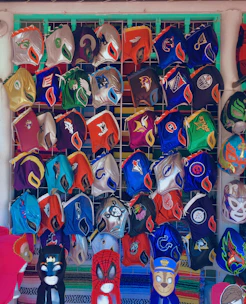 A lineup of various Spider-Man masks with different web patterns and red accents, displayed on futuristic stands.
