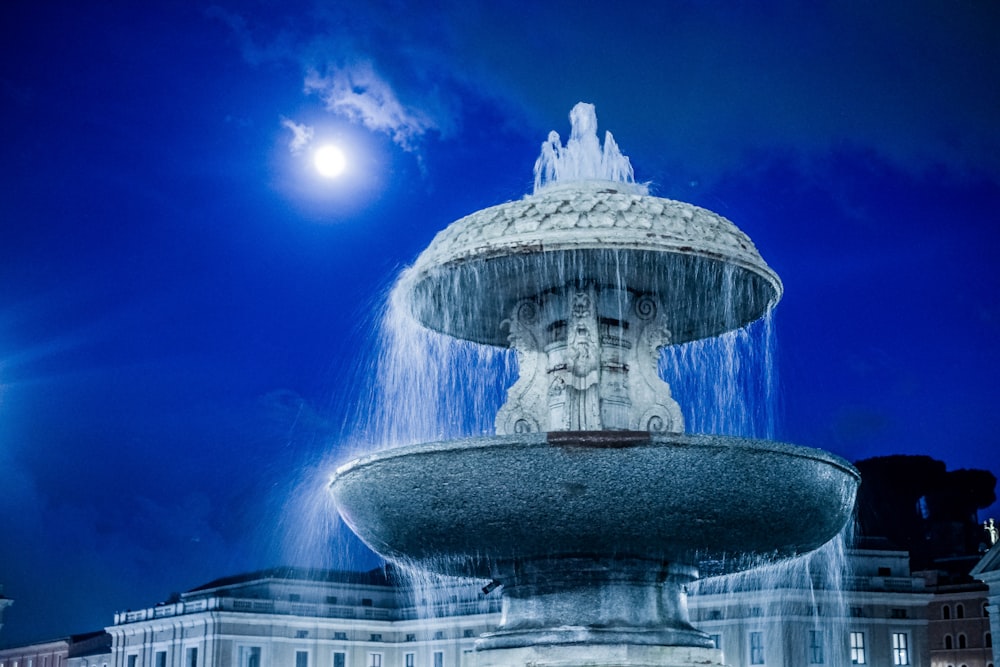 water fountain with lights turned on during night time