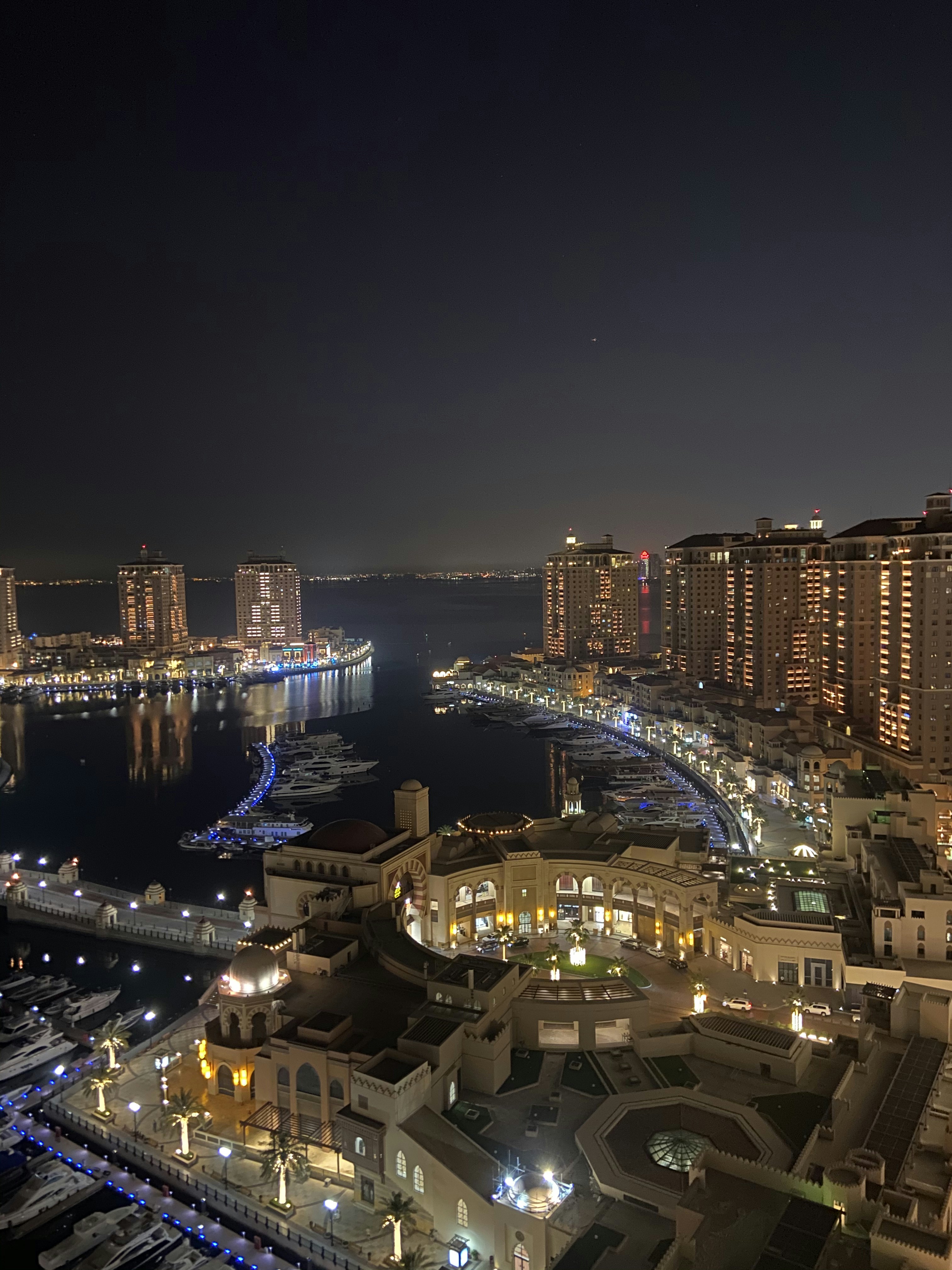 V&A Waterfront Cape Town at night with bright lights reflecting on the harbour water