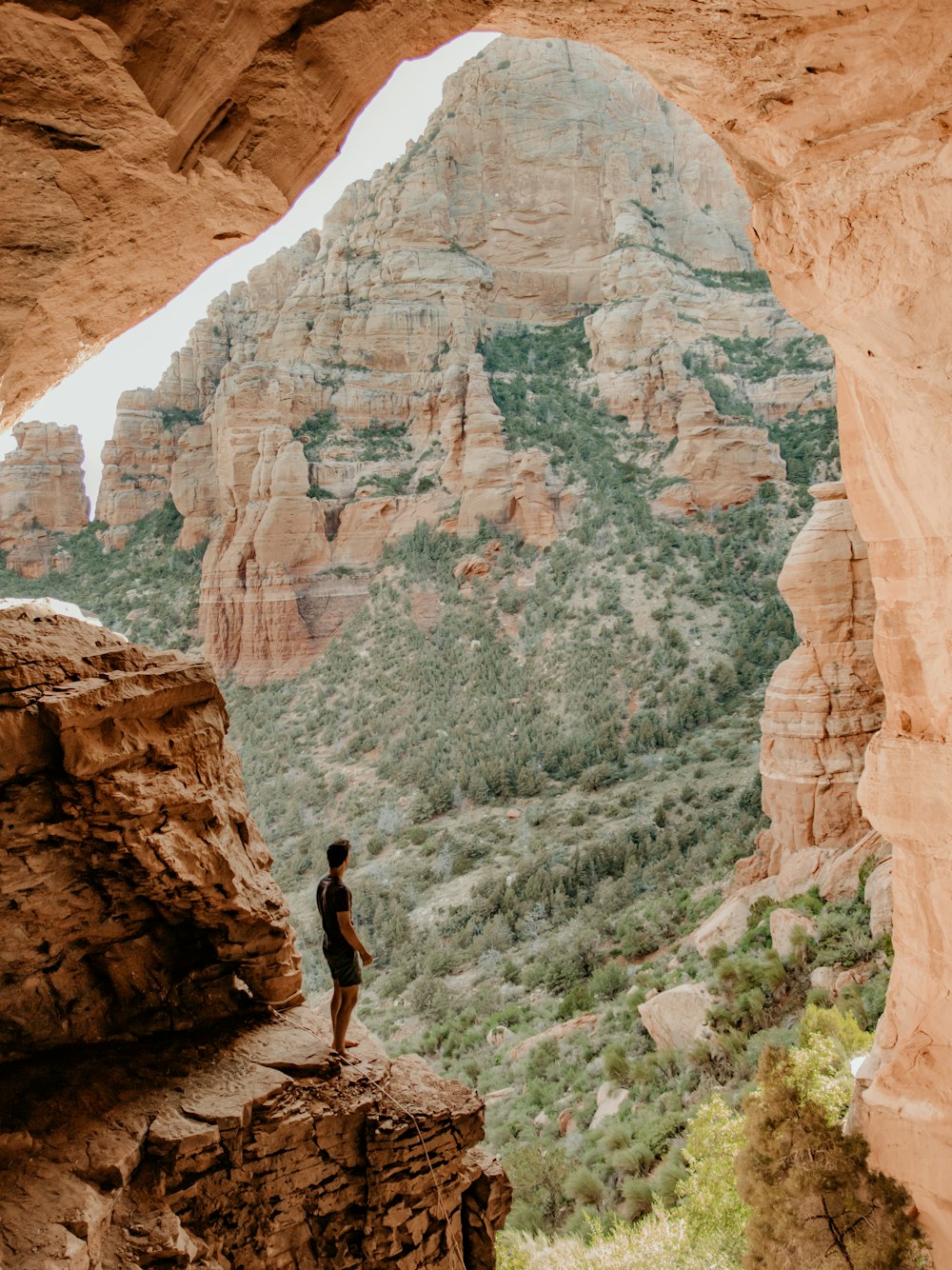 person in black shirt and black pants standing on brown rock formation during daytime