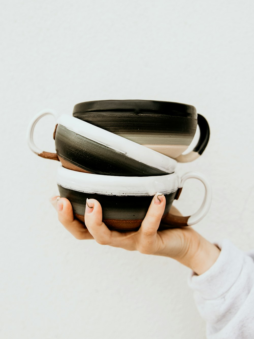 person holding black and white ceramic mug