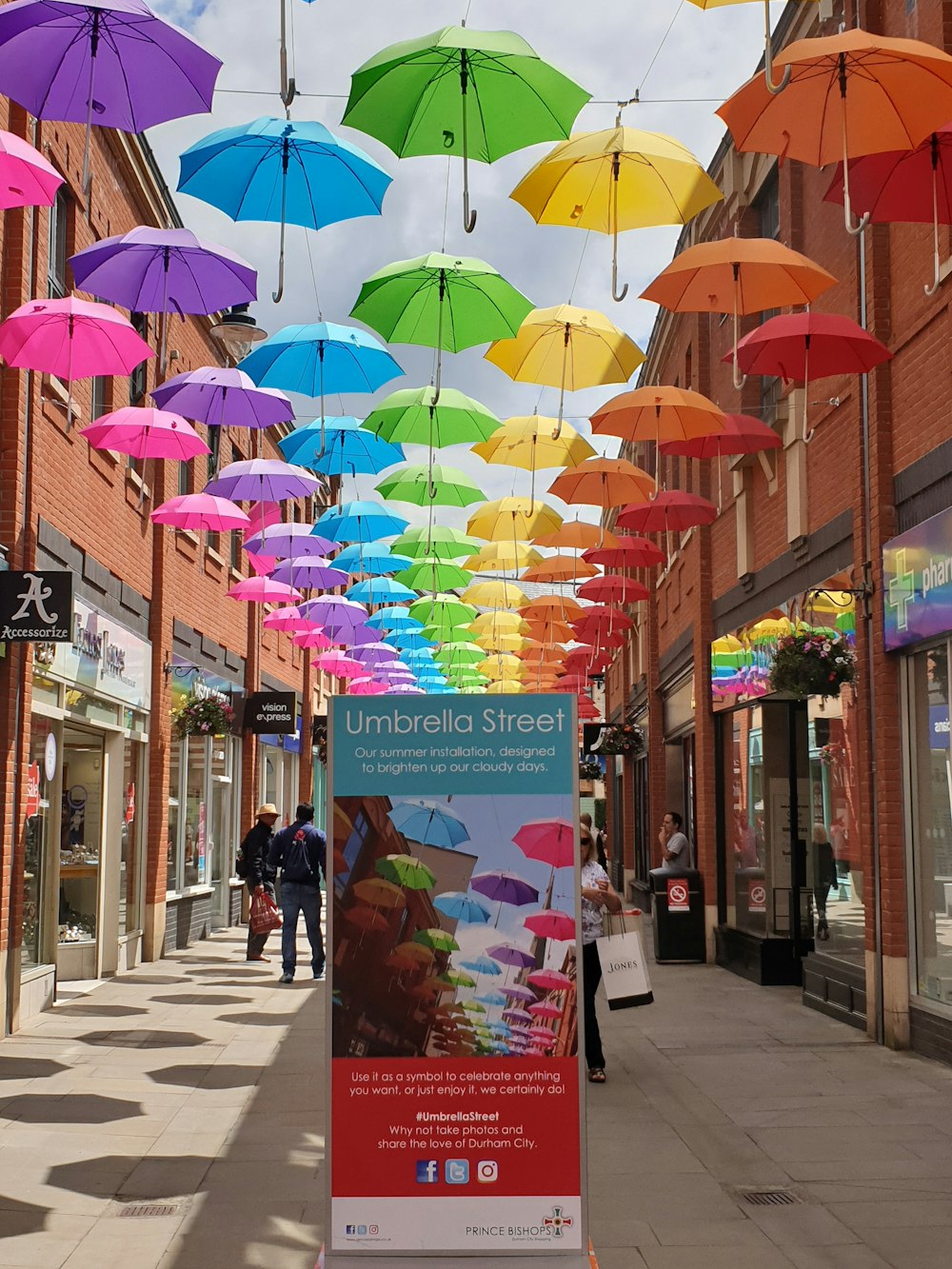 people walking on sidewalk with umbrella during daytime