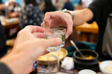 Close-up of hands clinking glasses during a lively event at Chartered Club.