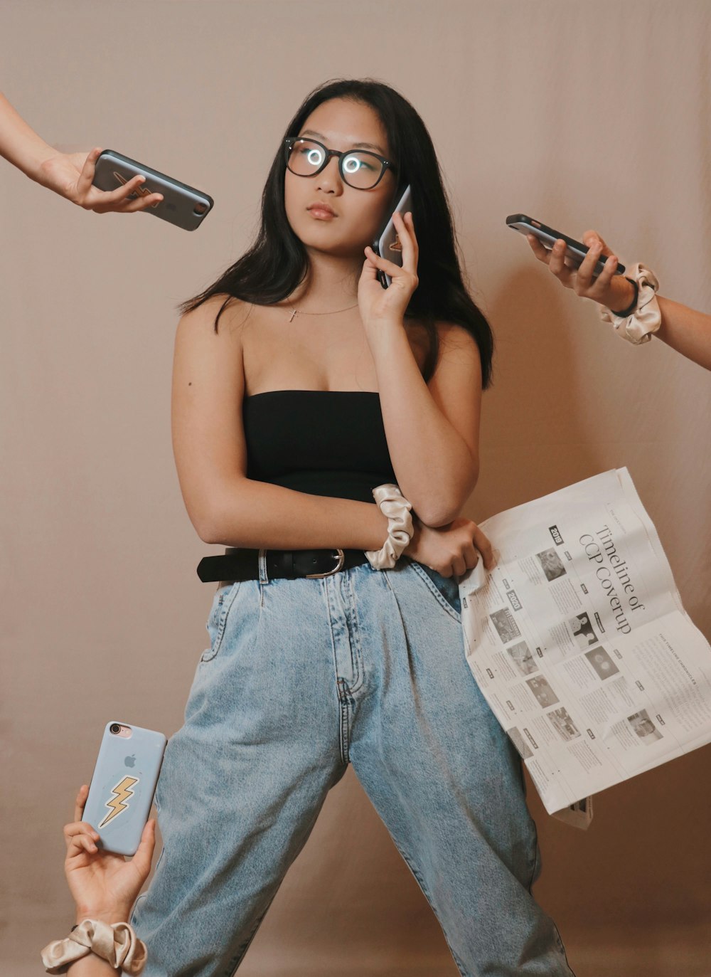 a woman holding a cell phone while standing next to another woman