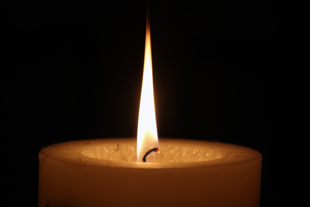 lighted candle in black background