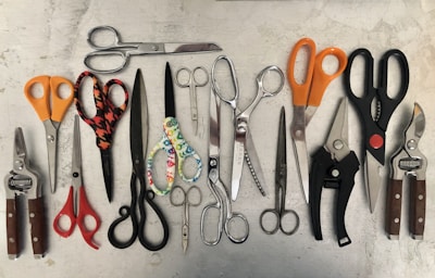 A colorful assortment of craft scissors with ergonomic handles arranged neatly on a plain background.