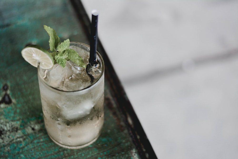 clear drinking glass with ice and black straw