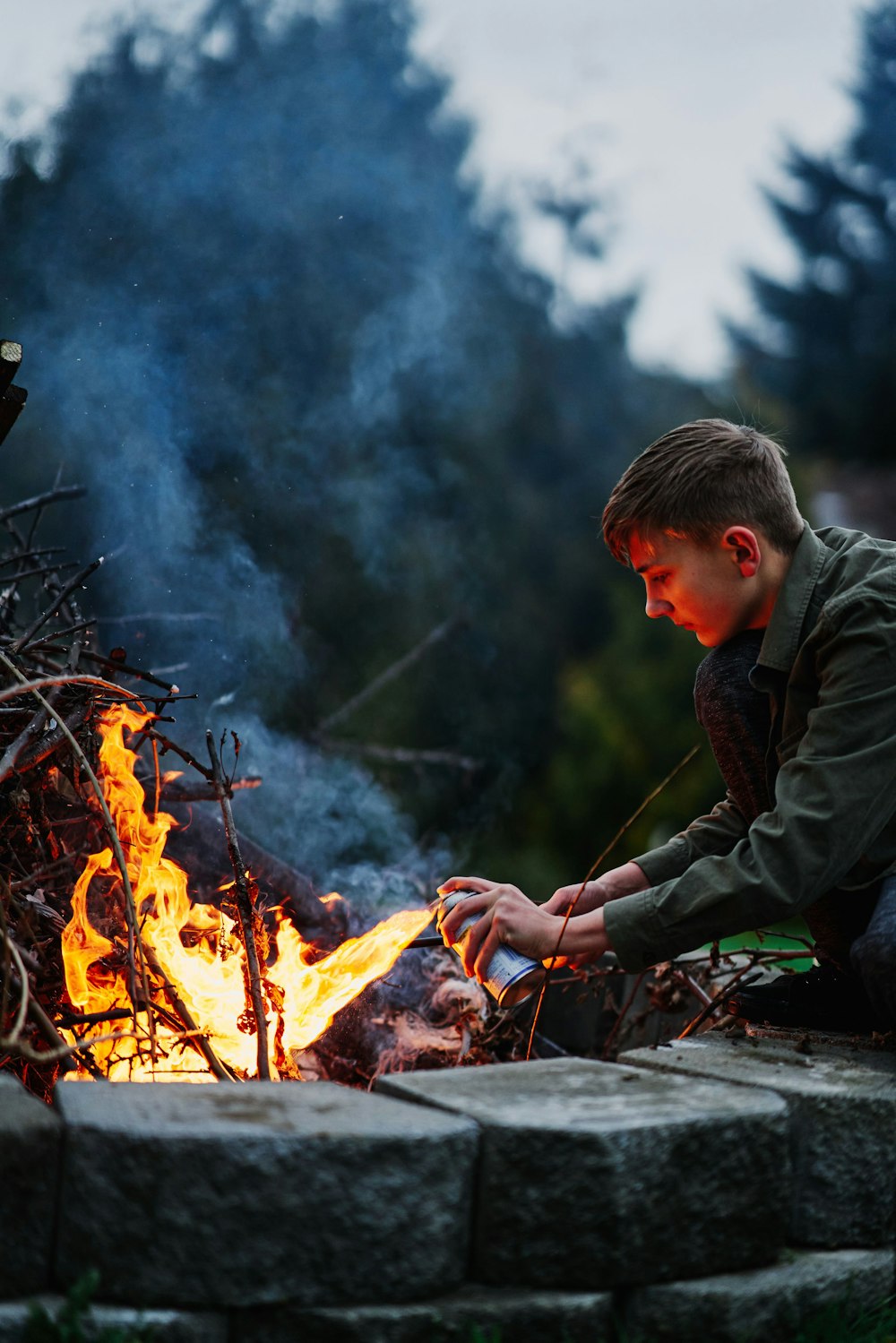 man in black jacket sitting on brown log