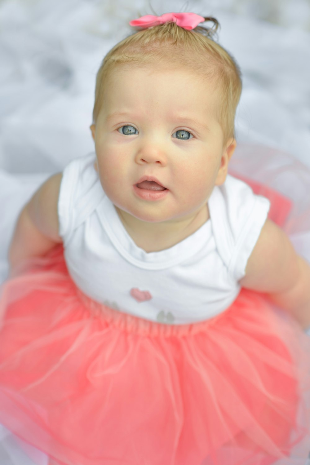 Baby in weißem und rosa Kleid