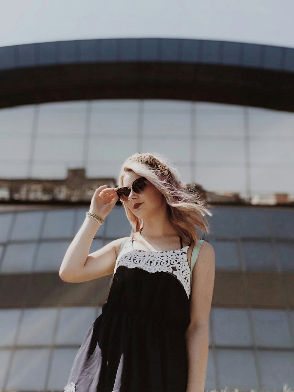 woman in black and white floral sleeveless dress wearing white framed sunglasses