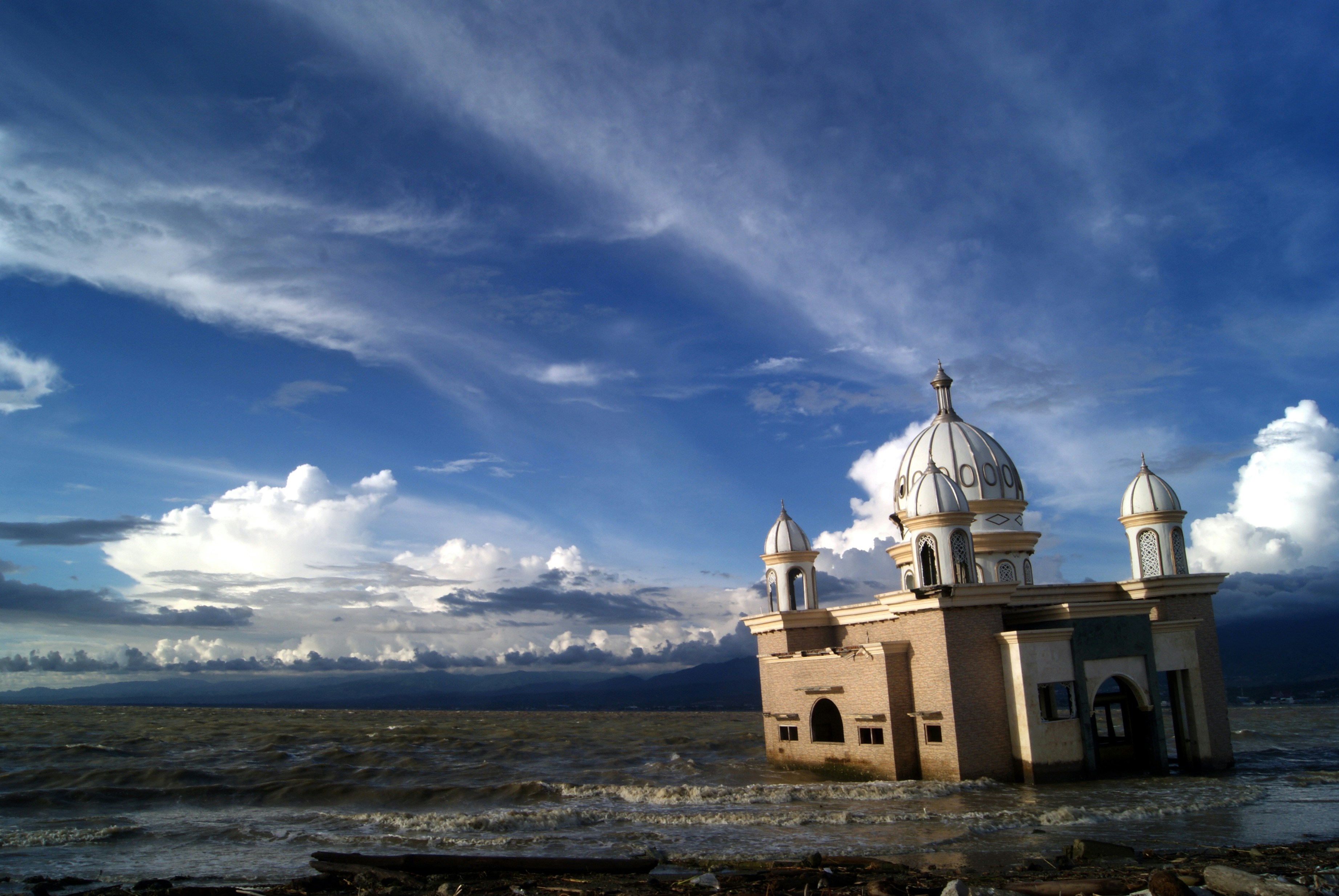 a building sitting in the middle of a body of water, A floating mosque collapsed due to the tsunami on September 28th 2018.