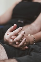 Close-up of two hands intertwined, symbolizing connection and trust.