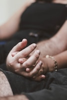A pair of intertwined hands, symbolizing complex relationships.