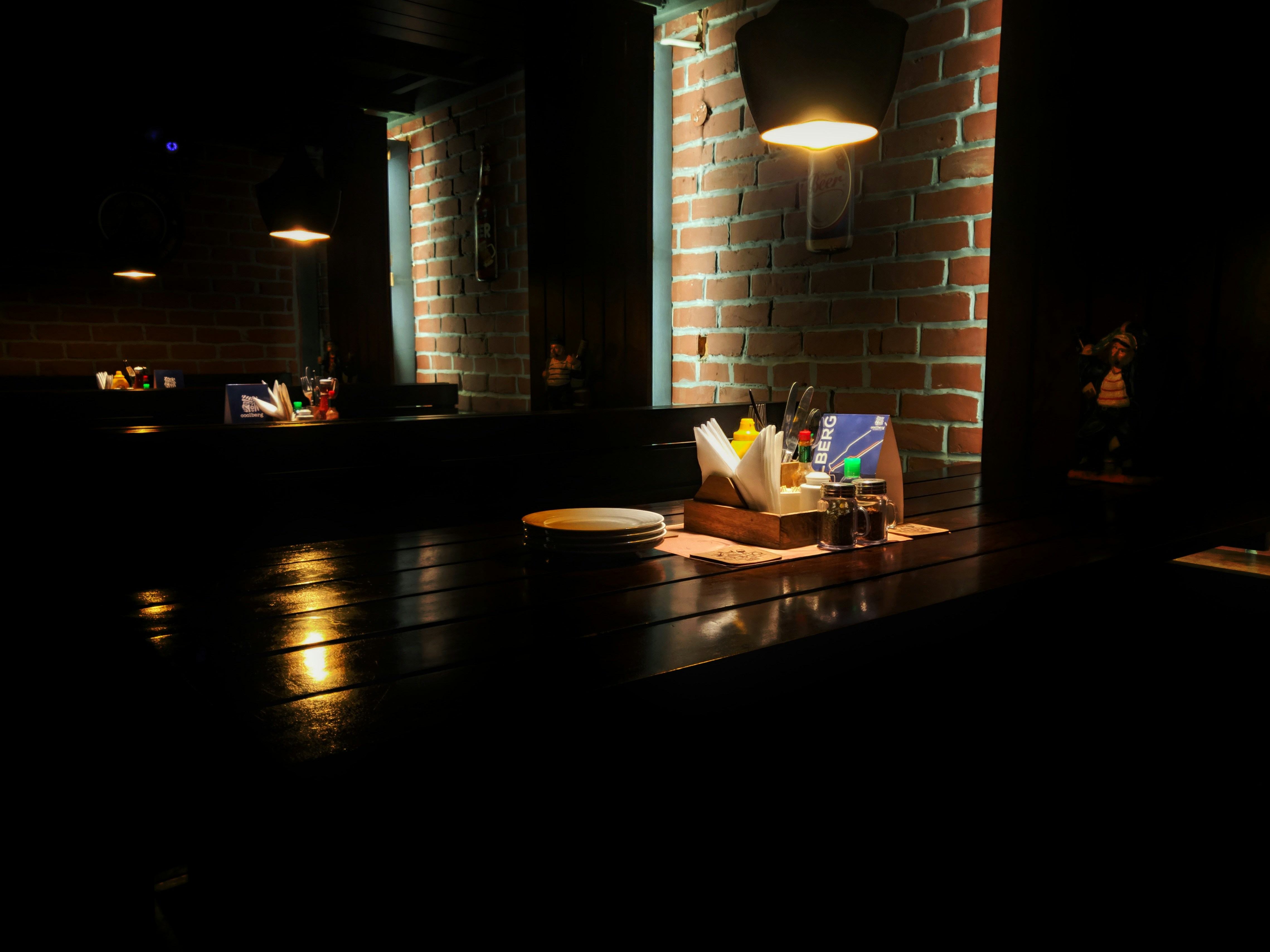 Restaurant with custom wood tables and pendant lighting, warm atmosphere, brick walls