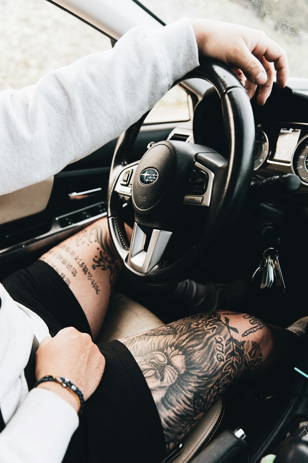 person in white long sleeve shirt driving car