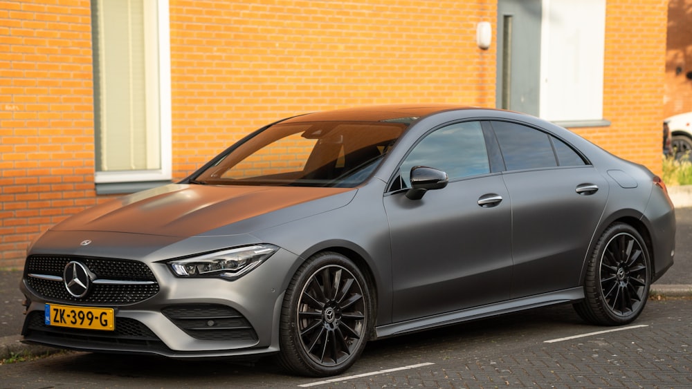 black mercedes benz c class parked beside brown brick building