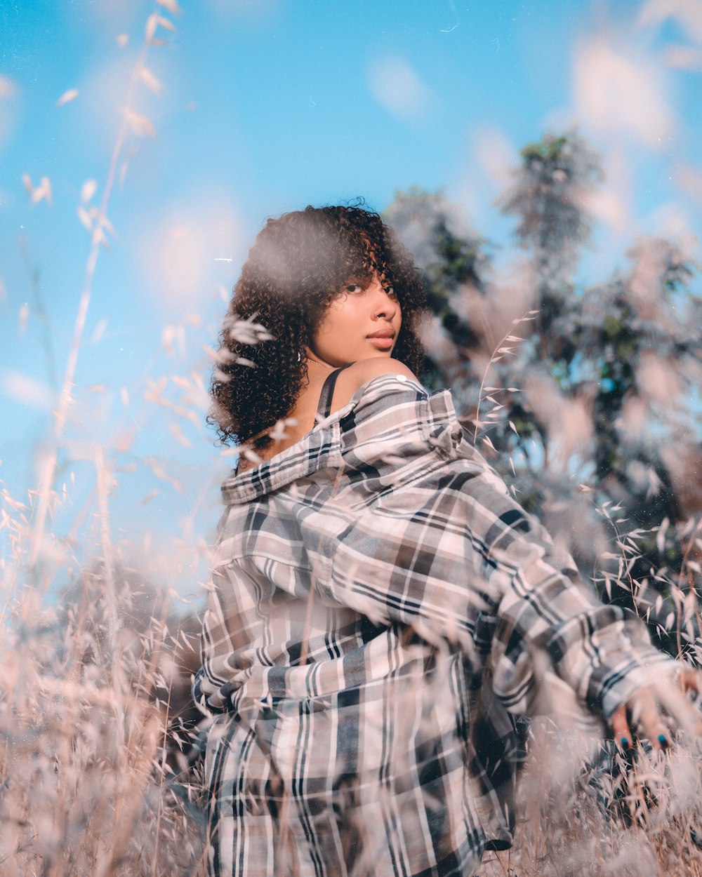 man in black and white plaid dress shirt standing on brown grass field during daytime