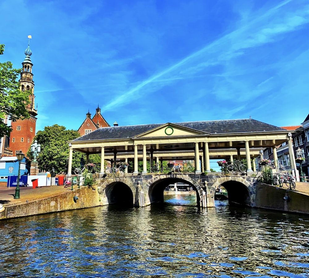 brown and white concrete building beside river under blue sky during daytime