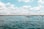 white boat on sea under blue sky and white clouds during daytime