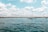 white boat on sea under blue sky and white clouds during daytime