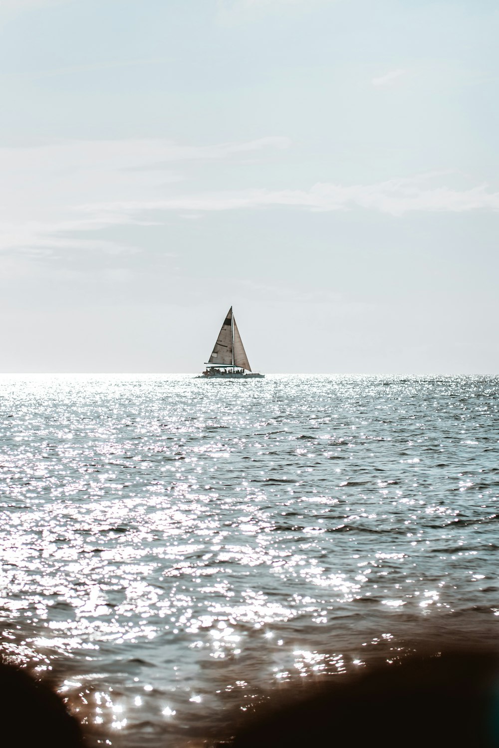 sailboat on sea under white sky during daytime