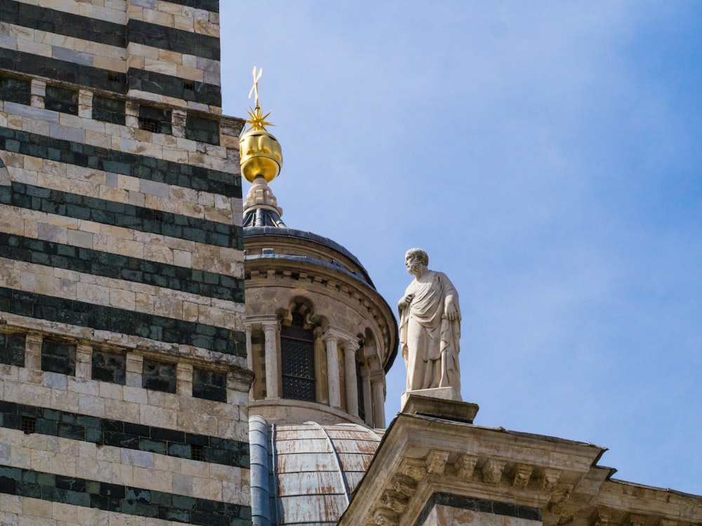 gold statue of man on top of building