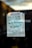A handwritten note taped to a glass door or window, stating 'CLOSED Will Re-open in June!!' with a smiley face underneath. The sign is written with green marker on a white piece of paper and is taped at the top corners.