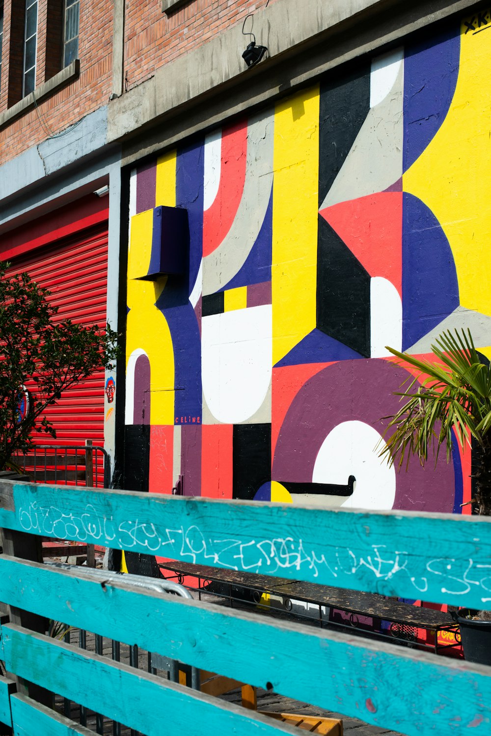 a blue bench sitting in front of a colorful wall