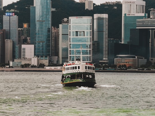 white and black boat on water near city buildings during daytime in Tsim Sha Tsui Hong Kong