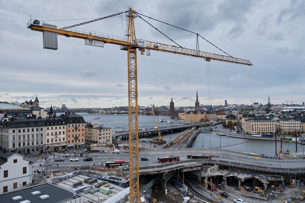 yellow crane near city buildings during daytime