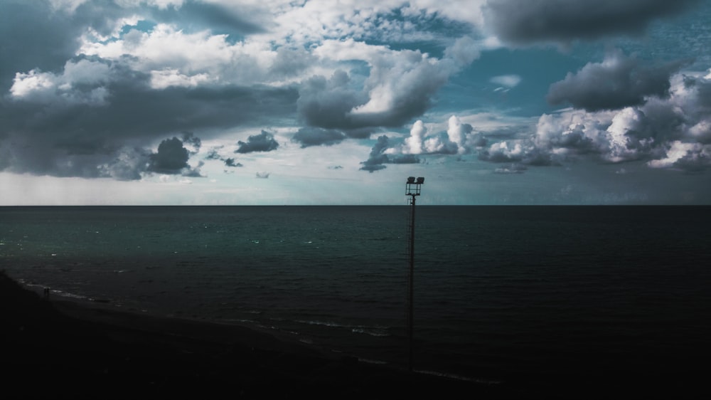 sea under white clouds and blue sky during daytime