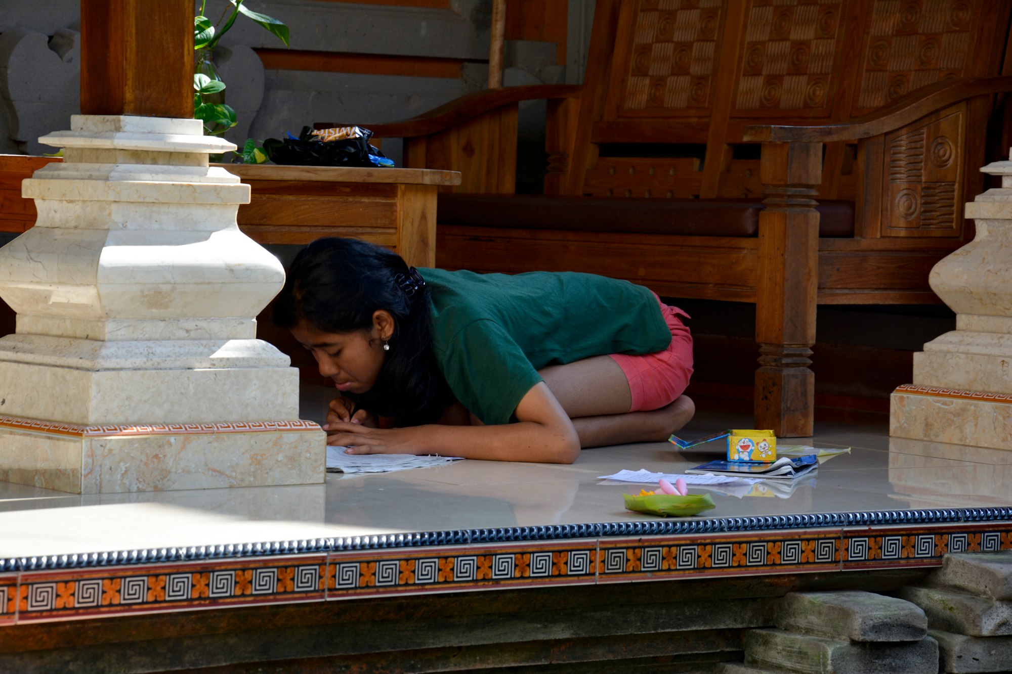 Balinese girl studying on a terrace