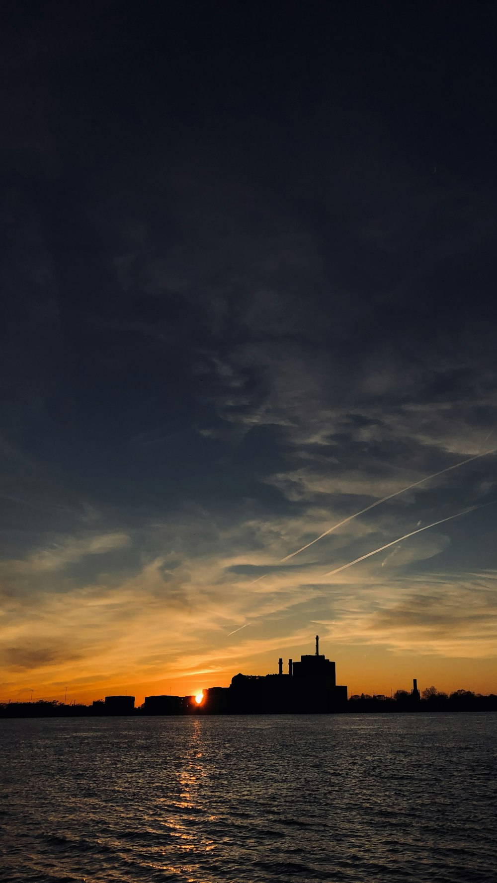 silhouette of building under cloudy sky during sunset