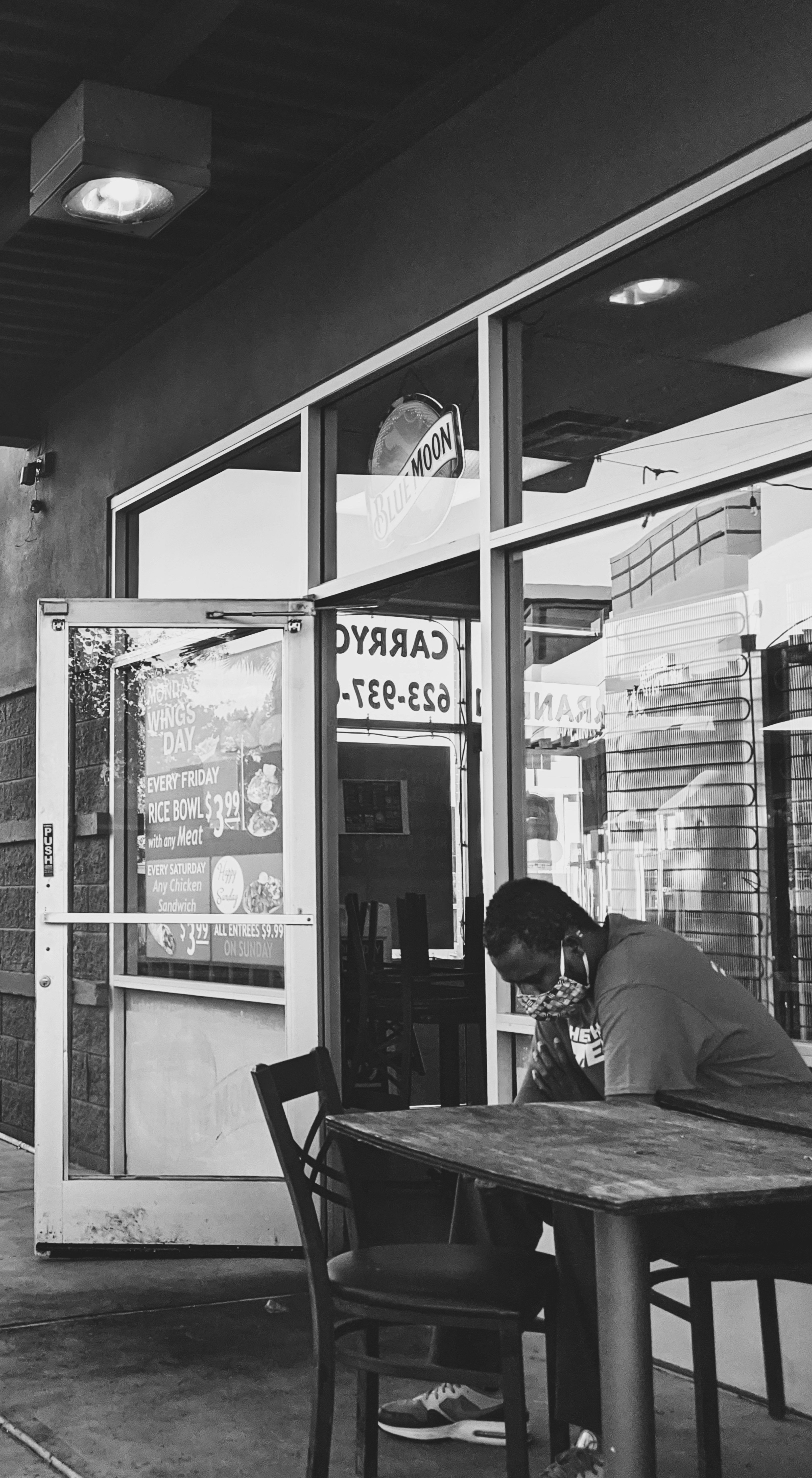 man in black jacket sitting on chair in front of store