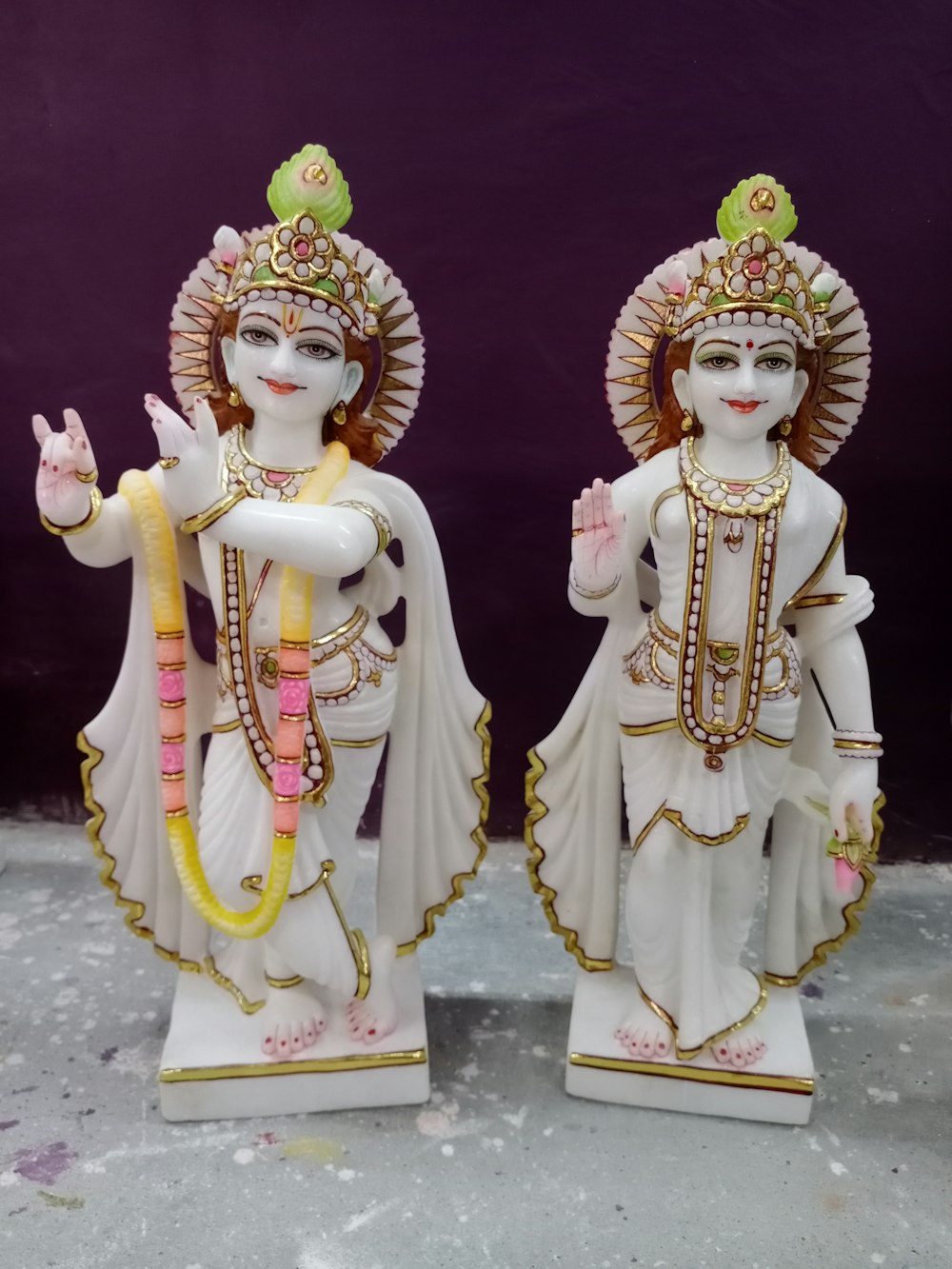 2 estatuetas de divindades hindus douradas e vermelhas