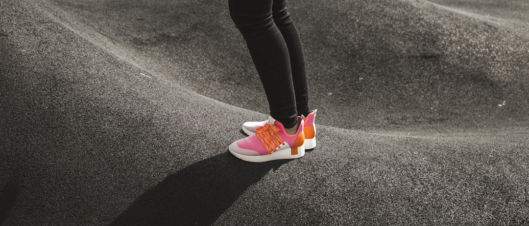person in pink and white nike sneakers